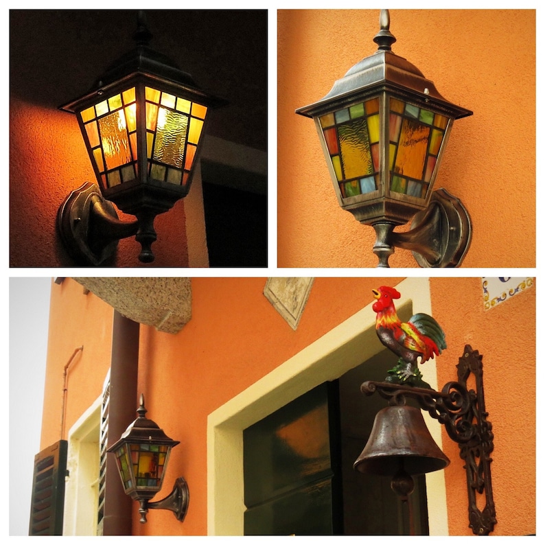 May include: A collection of outdoor wall-mounted lanterns with stained glass panels in shades of yellow, orange, and green. The lanterns have a dark metal finish and are mounted on an orange wall. One image shows a rooster bell.