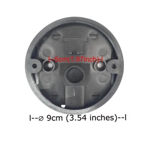 May include: A black, circular component with a diameter of 3.54 inches (9 cm). The component has several holes and a central opening. The text "UP" is visible, indicating the correct orientation. The component's width is 1.97 inches (5 cm).