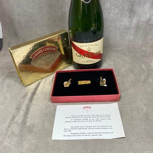 Caja de coleccionista con 3 pins vintage de champán Mumm Cordon Rouge de Arthus Bertrand. Fabricada en Francia en la década de 1980.