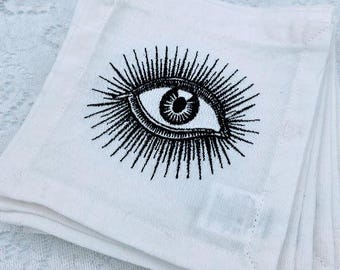 Servilletas de cóctel bordadas "Ojos" de Jonathan Adler – Juego de 6 con diseño de ojos en blanco y negro con efecto rayos de sol.