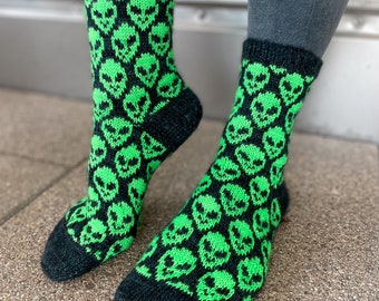 May include: Black and green socks with a pattern of alien faces.