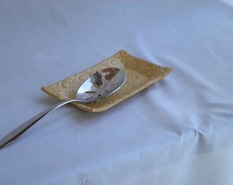 Gold colored stoneware doily spoon rest