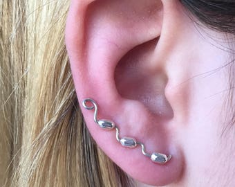 Sterling silver ear sweeps, made with 925 silver wire and  oblong 5 mm sterling silver beads, wind up the ear in an intriguing design.
