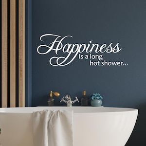 May include: White vinyl wall decal with the text "Happiness is a long hot shower..." on a dark blue wall above a white bathtub.