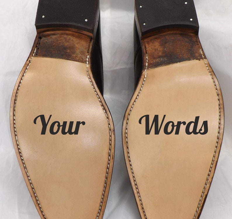 May include: A pair of brown leather shoes with the words "Your" and "Words" written on the soles.