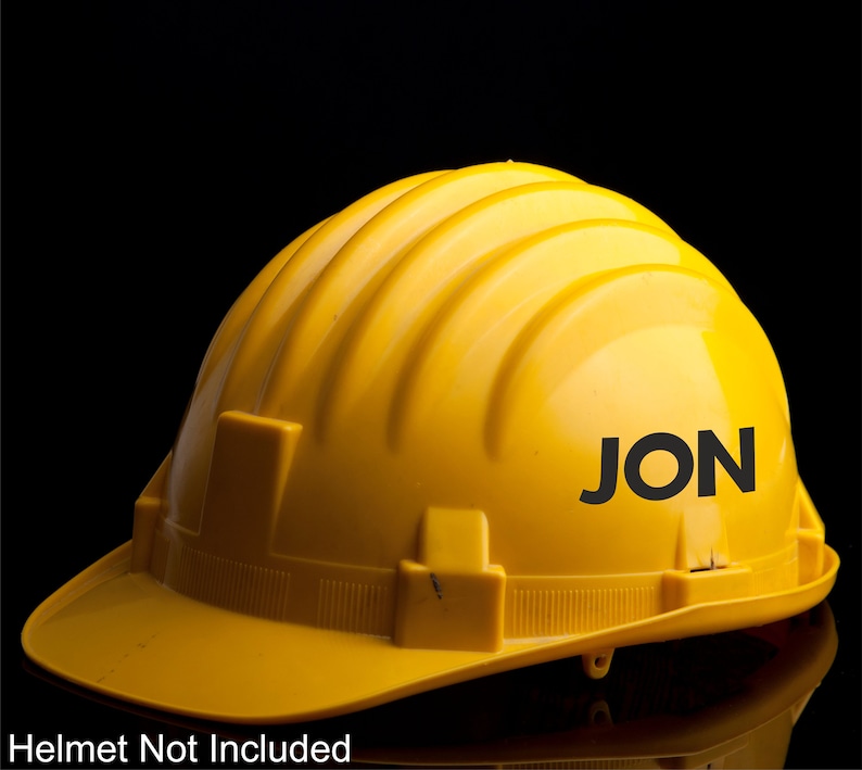 May include: A yellow hard hat with the name "JON" printed in black letters on the side.