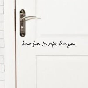 Op de afbeelding: Witte deur met een zilveren deurknop en de tekst "have fun, be safe, love you..." in zwart.