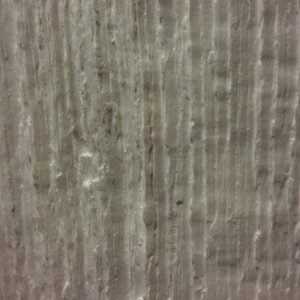 May include: A close-up of a textured, light gray wall with vertical lines. The wall has a rough, uneven surface.