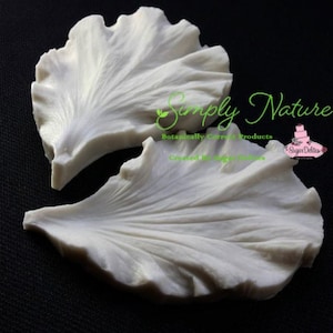 May include: Two white silicone molds for making sugar flower petals. The molds are designed to create realistic-looking petals with a ruffled edge. The molds are made by Simply Nature, Botanically Correct Products.