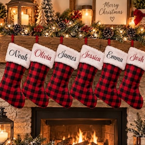 May include: Six Christmas stockings featuring a red and black buffalo plaid pattern with white faux fur cuffs. Each cuff is personalized with the embroidered names Noah, Olivia, James, Jessica, Emma, and Josh in a black cursive script font.