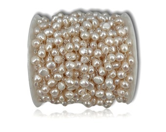 Op de afbeelding: Een spoel met witte parel- en zilveren ketting, perfect voor het maken van sieraden of om een ​​toets van elegantie toe te voegen aan uw knutselwerk.
