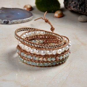 May include: A multi-strand leather wrap bracelet with white pearls, light blue and brown stones, and silver accents.