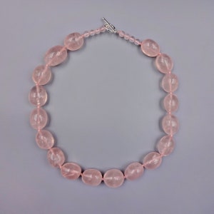 Puede incluir: Un collar de cuentas de cuarzo rosa con cierre de plata.