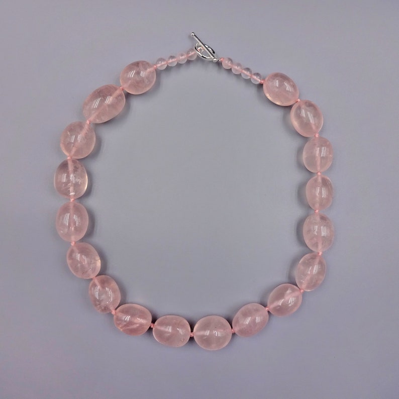 Puede incluir: Un collar de cuentas de cuarzo rosa con cierre de plata.