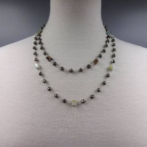 May include: A double-strand necklace with silver chain and dark gray, green, and brown square beads.
