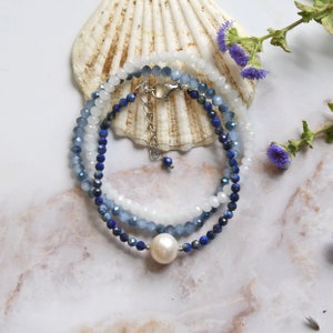 May include: A layered bracelet with blue and white beads, a white pearl charm, and a silver clasp.
