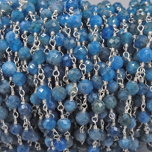 May include: A chain of blue kyanite beads with silver wire accents. The beads are faceted and have a slightly irregular shape. The chain is approximately 18 inches long.