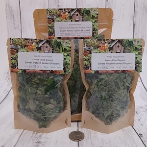 May include: Three brown paper pouches filled with freeze-dried sweet potato leaves. Each pouch has a label that reads "Wood House Farm Freeze-Dried Organic Sweet Potato Leaves (4 types)". A quarter is at the bottom of the image.