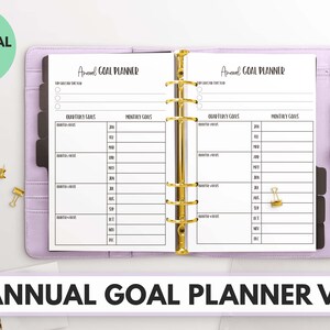 Peut inclure: Un classeur violet avec une page blanche ouverte sur un planificateur de buts. Le planificateur comporte des sections pour les objectifs trimestriels et les objectifs mensuels. Le texte "Annual Goal Planner" est en haut de la page.