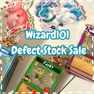 May include: Image showing Wizard101 merchandise, including character charms and trading cards. The charms depict a pink pig with wings and a white unicorn with blue hair. The cards feature a fairy and other game elements. Text reads "Wizard101 Defect Stock Sale."