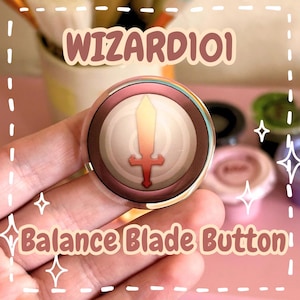 Peut inclure: Un bouton circulaire présentant un graphique d'une épée rouge centrée sur un fond beige clair avec une bordure marron foncé. Le texte WIZARD101 est imprimé au-dessus du bouton et le texte Balance Blade Button est imprimé en dessous.