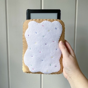 May include: A felt e-reader cover shaped like a pop-tart with white frosting and colourful sprinkles.