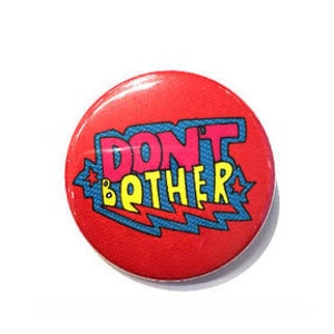 Könnte beinhalten: Runder roter Knopf mit einem weißen Stern auf jeder Seite des Textes "DON'T BOTHER" in einer bunten Comic-Schriftart.
