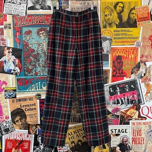 May include: A pair of black and red checked trousers with a high waist and a wide leg.