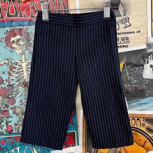 May include: A pair of dark blue pinstripe pants with a wide leg.