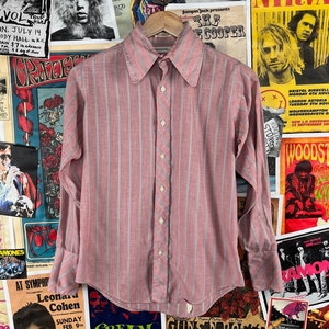 May include: A pink and gray striped long-sleeve button-down shirt with a pointed collar.
