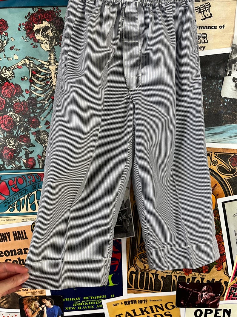 May include: Blue and white striped pajama pants with an elastic waistband and white stitching. The pants are made of a lightweight fabric and have a relaxed fit. The pants are approximately 30 inches long.