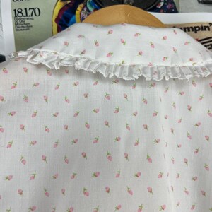 K&ouml;nnte beinhalten: Wei&szlig;e Baumwollbluse mit R&uuml;schenkragen und kleinem rosafarbenem Blumenmuster.