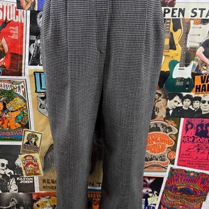 Pode incluir: Cal&ccedil;a de xadrez preto e branco de cintura alta e fecho de bot&atilde;o. A cal&ccedil;a tem perna reta e &eacute; feita de um tecido leve.