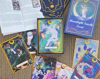 Può includere: Un mazzo di tarocchi intitolato The Moonlight Senshi Tarot, composto da una scatola blu con accenti a mezzaluna dorati, un libretto di istruzioni e diverse carte illustrate con personaggi in stile anime, bacchette magiche e gatti, con bordi dorati.