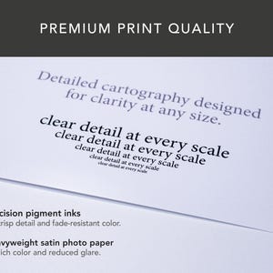 May include: A close-up of a white paper with text that reads "PREMIUM PRINT QUALITY". The text on the paper includes "Detailed cartography designed for clarity at any size" and "clear detail at every scale". The bottom of the paper reads "Precision pigment inks" and "Heavyweight satin photo paper".