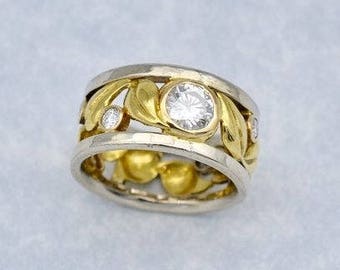 18k yellow and white gold leaf design wedding band with .05ct diamonds all around featuring 1ct VS2,F color, excellent cut round diamond!