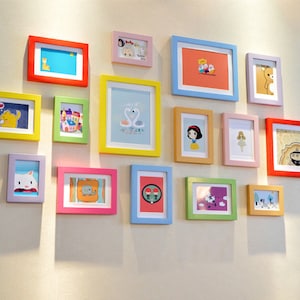 May include: A wall gallery featuring a collection of colorful picture frames with various images and designs. The frames are arranged in a staggered pattern, creating a visually appealing display.