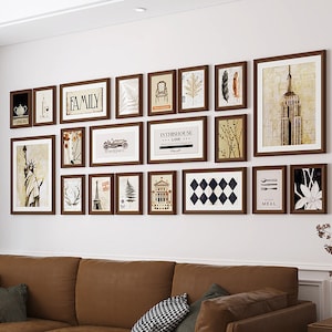 May include: A gallery wall with 15 framed prints in various styles and colors. The prints include images of a cityscape, a car, a tree, a building, a feather, a deer head, a fork and knife, a flower, and more. The frames are all brown wood.