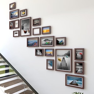 May include: A wall gallery featuring a collection of brown picture frames with various images, including landscapes, seascapes, and abstract designs. The frames are arranged in a diagonal pattern, creating a visually appealing and modern look.