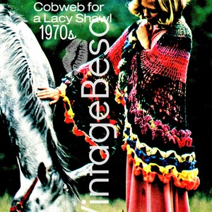 May include: A woman wearing a colorful crocheted shawl with a ruffled edge, standing in a field with a white horse. The shawl is made with a cobweb stitch and has a variety of colors, including red, yellow, blue, and green. The text "Crochet a Color Cobweb for a Lacy Shawl 1970s" is visible at the top of the image.