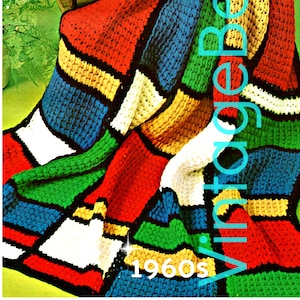 May include: A colorful crocheted blanket with a geometric pattern in shades of red, blue, green, yellow, white, and black. The blanket is draped over a wooden rocking chair. The text "1960s Vintage Bess" is visible in the image.