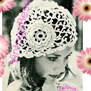 May include: A white crocheted hat with a large floral design. The hat is worn by a woman with short hair. The image is from the 1970s.