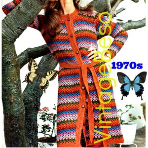 May include: A vintage 1970s crochet pattern for a long, striped cardigan with a belt. The cardigan is made with a variety of colors, including orange, pink, blue, and green. The model is wearing the cardigan with a belt tied at the waist.