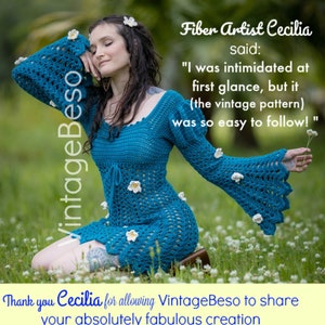 Puede incluir: Una mujer lleva un vestido de crochet azul con flores de crochet blancas. El vestido tiene mangas acampanadas y un patrón de crochet. La mujer está sentada en un campo de flores blancas. "Fiber Artist Cecilia dijo: "Me intimidó a primera vista, pero (el patrón vintage) fue tan fácil de seguir!" Gracias a Cecilia por permitir que VintageBeso comparta tu creación absolutamente fabulosa (Cecilia agregó flores - ella y ellas son encantadoras!)"