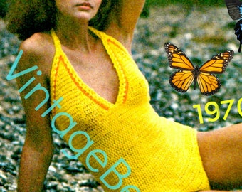 Puede incluir: Una mujer lleva un traje de baño de halter amarillo tejido a crochet. El traje de baño tiene un escote en V y ribetes naranjas. La mujer está sentada en un lecho de rocas con mariposas en el fondo. El texto "VintageBeso 1970" es visible en la imagen.