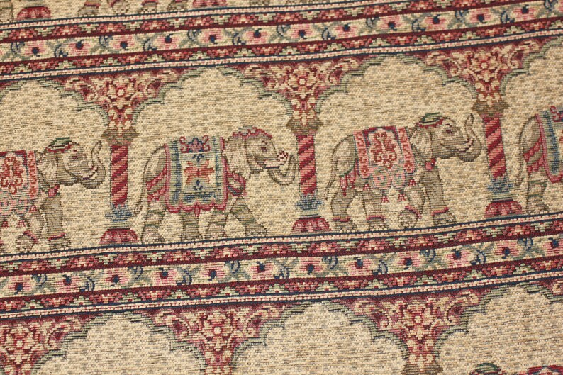 May include: Beige fabric with a repeating pattern of elephants, arches, and floral designs in shades of red, blue, and green.