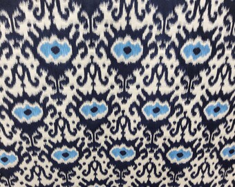 May include: A navy blue and white fabric with an ikat pattern. The pattern features a repeating design of blue and white swirls and diamonds.