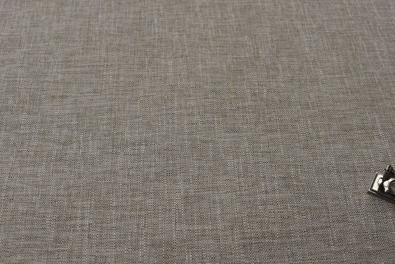 May include: A close-up of a light brown fabric with a subtle woven texture.