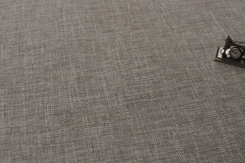 May include: A close-up of a light brown fabric with a woven texture.