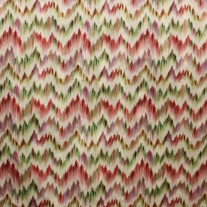 Op de afbeelding: Een witte stof met een chevron-patroon in tinten rood, groen en paars.